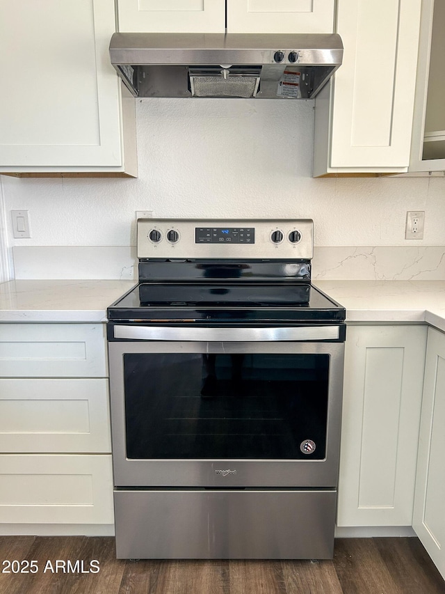 kitchen featuring stainless steel range with electric stovetop, ventilation hood, light countertops, and dark wood-type flooring