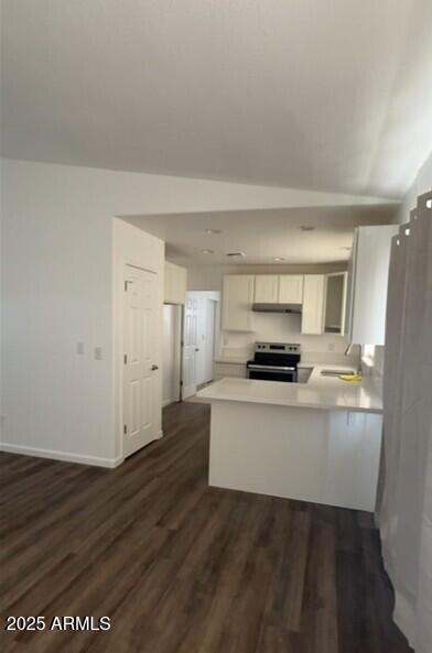 kitchen featuring stainless steel range with electric cooktop, a peninsula, white cabinets, and light countertops