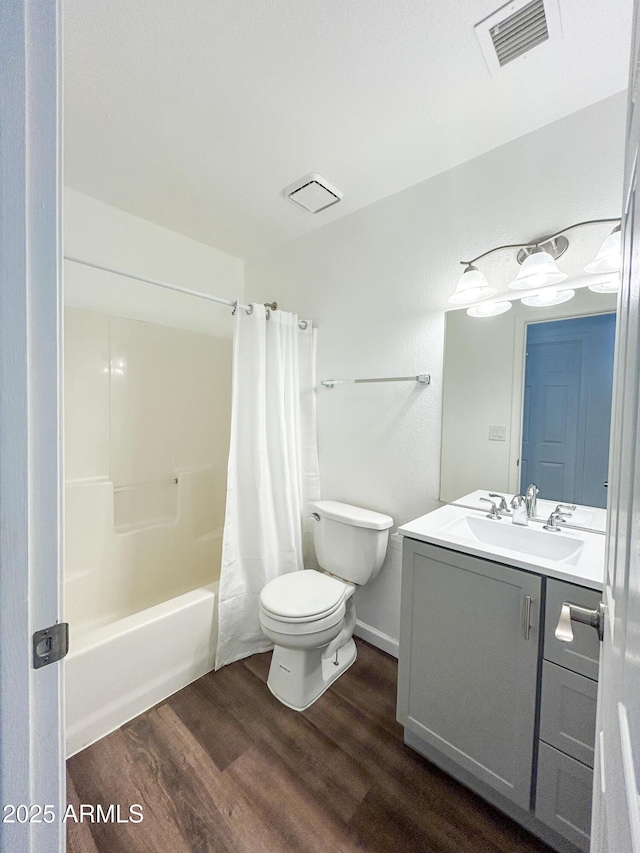 full bath featuring wood finished floors, toilet, vanity, and shower / bathtub combination with curtain