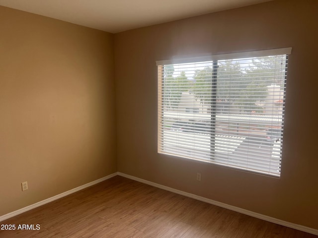 empty room with baseboards and wood finished floors