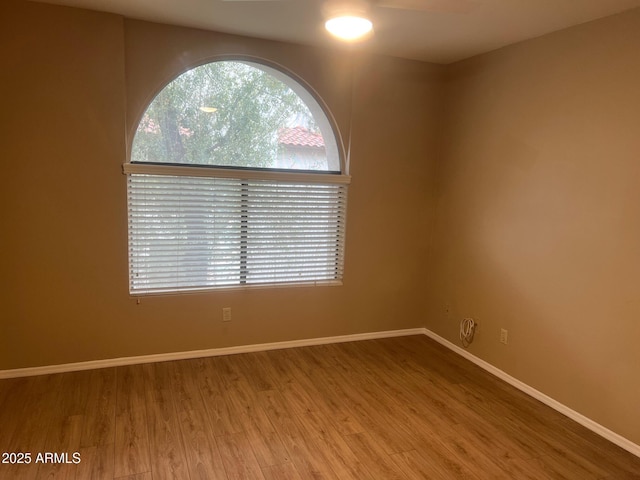 empty room with wood finished floors and baseboards