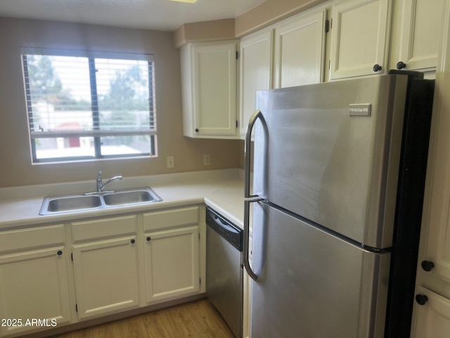 kitchen featuring a sink, white cabinets, plenty of natural light, and stainless steel appliances