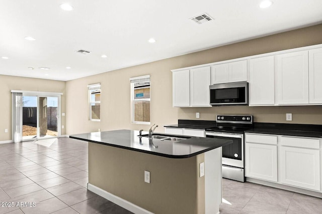 kitchen with dark countertops, appliances with stainless steel finishes, a sink, and visible vents