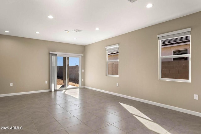 empty room featuring visible vents, baseboards, and tile patterned flooring