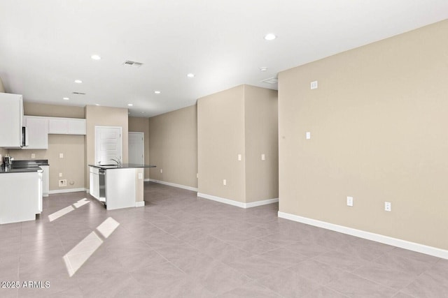 unfurnished living room with a sink, baseboards, recessed lighting, and visible vents