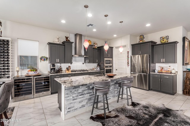 kitchen with appliances with stainless steel finishes, wine cooler, marble finish floor, and wall chimney exhaust hood