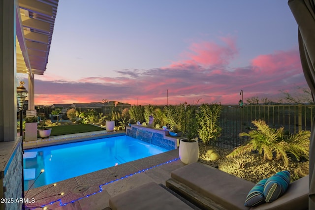 pool at dusk featuring a fenced in pool and fence