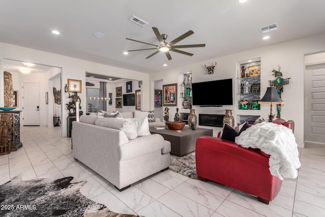 living room with marble finish floor, visible vents, a glass covered fireplace, and recessed lighting