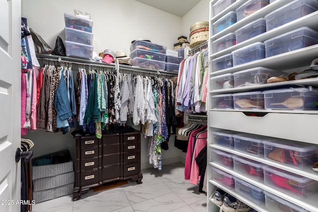 walk in closet featuring marble finish floor