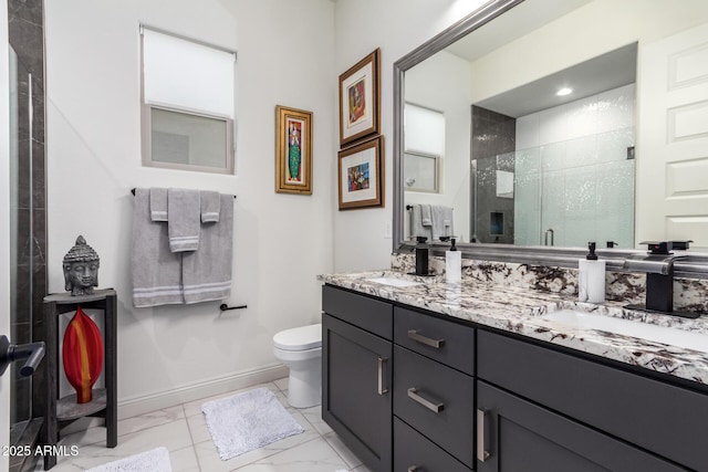 bathroom with marble finish floor, a stall shower, a sink, and toilet