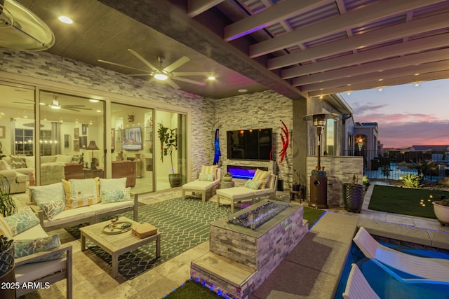 view of patio / terrace with an outdoor living space with a fire pit and a ceiling fan