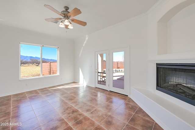 unfurnished living room with crown molding, ceiling fan, a mountain view, and tile patterned flooring