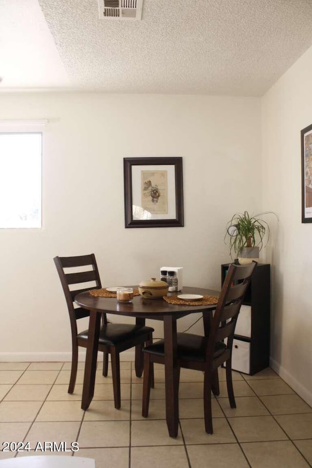 dining area with tile patterned floors and a textured ceiling