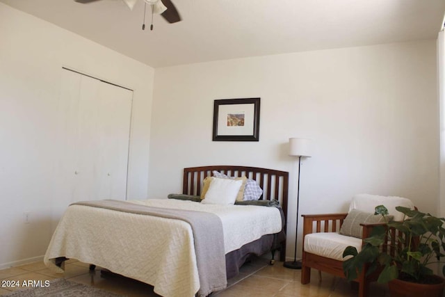 tiled bedroom featuring ceiling fan and a closet