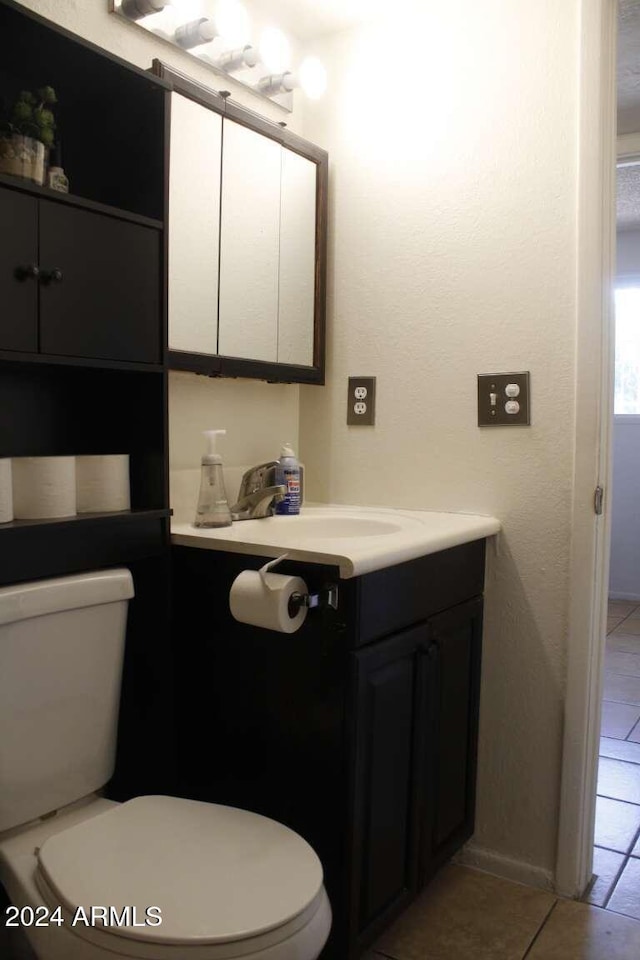 bathroom with tile patterned flooring, vanity, and toilet