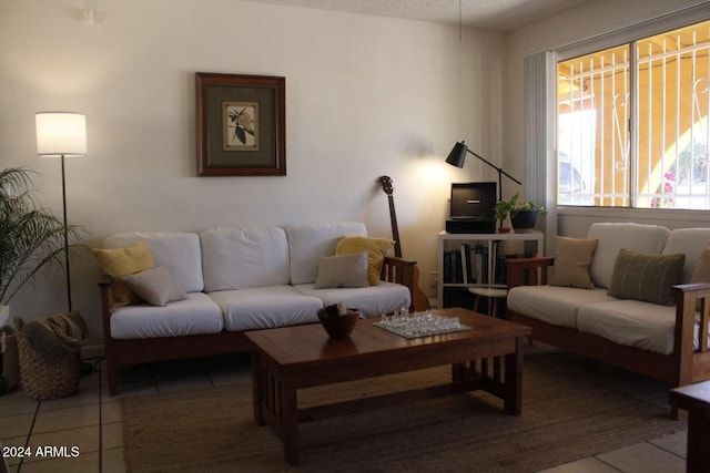 living room with a textured ceiling and light tile patterned flooring