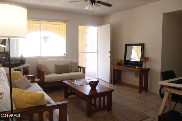 tiled living room with ceiling fan and a textured ceiling