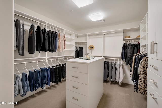 walk in closet featuring light colored carpet