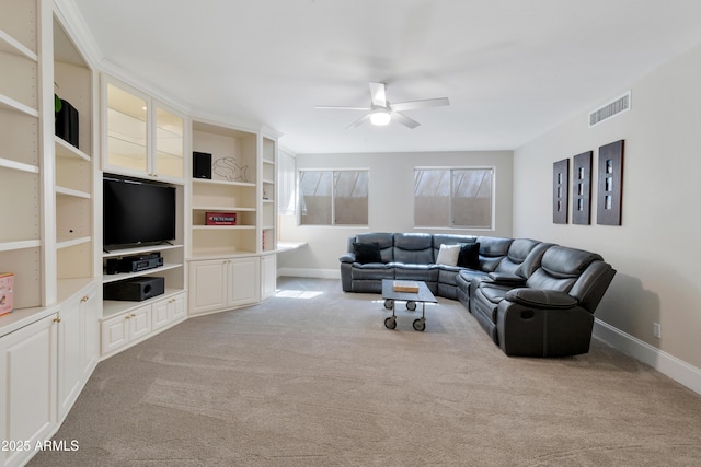 carpeted living area featuring baseboards, visible vents, and a ceiling fan