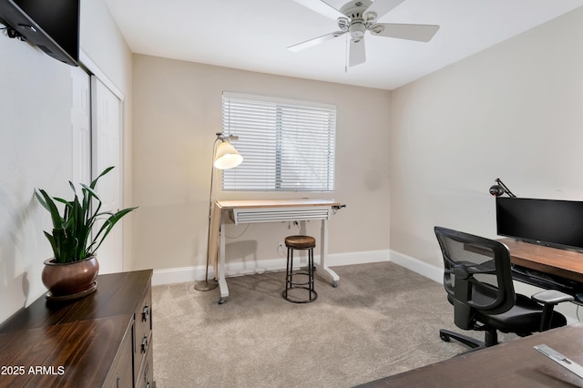 carpeted office featuring a ceiling fan and baseboards