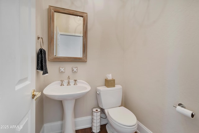 half bath with toilet and baseboards