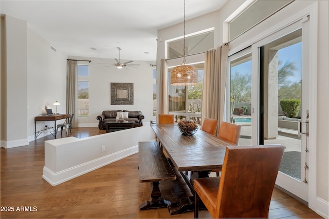 dining room featuring a wealth of natural light, wood finished floors, visible vents, and baseboards