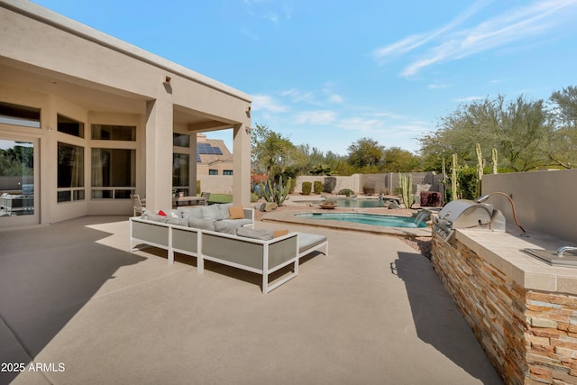 view of swimming pool featuring a fenced in pool, a patio, an outdoor kitchen, a grill, and a fenced backyard