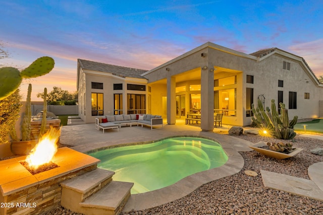 back of house featuring a patio area, an outdoor living space with a fire pit, and stucco siding