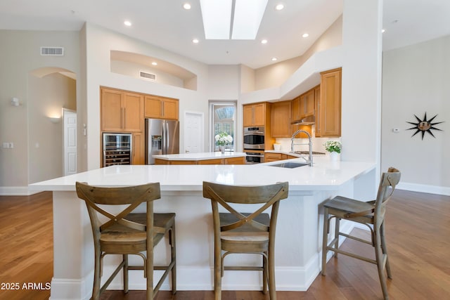 kitchen with appliances with stainless steel finishes, arched walkways, visible vents, and a sink