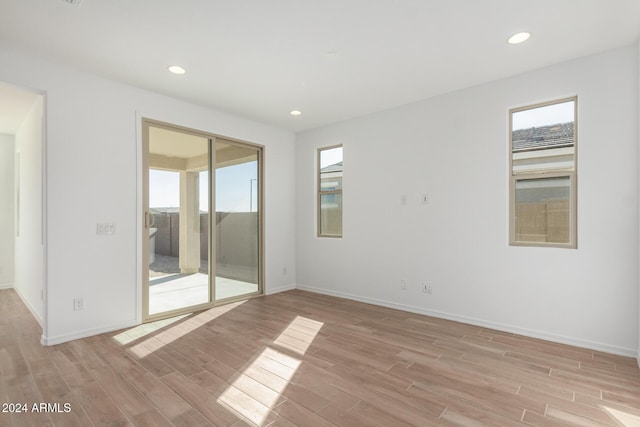 spare room with light wood-type flooring and plenty of natural light