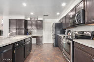 kitchen featuring appliances with stainless steel finishes, sink, and dark brown cabinetry