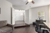 home office with dark hardwood / wood-style floors and ceiling fan