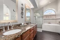 bathroom featuring vanity, shower with separate bathtub, vaulted ceiling, and hardwood / wood-style floors