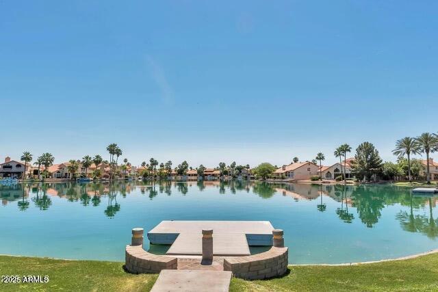 dock area with a water view and a yard