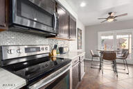 kitchen featuring tasteful backsplash, ceiling fan, appliances with stainless steel finishes, and dark brown cabinetry