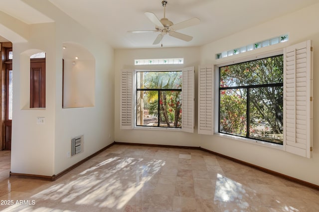 empty room with ceiling fan and a healthy amount of sunlight