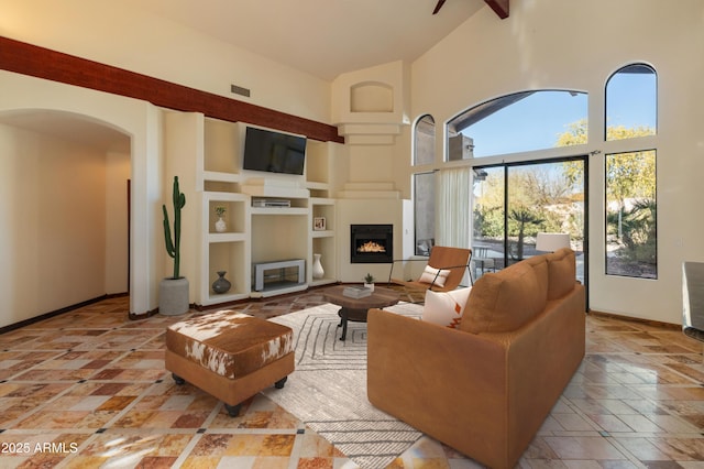 living room with built in shelves and high vaulted ceiling