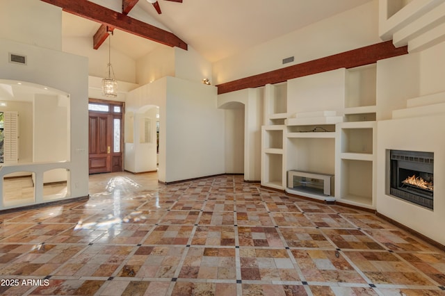 unfurnished living room with beam ceiling, high vaulted ceiling, and built in features