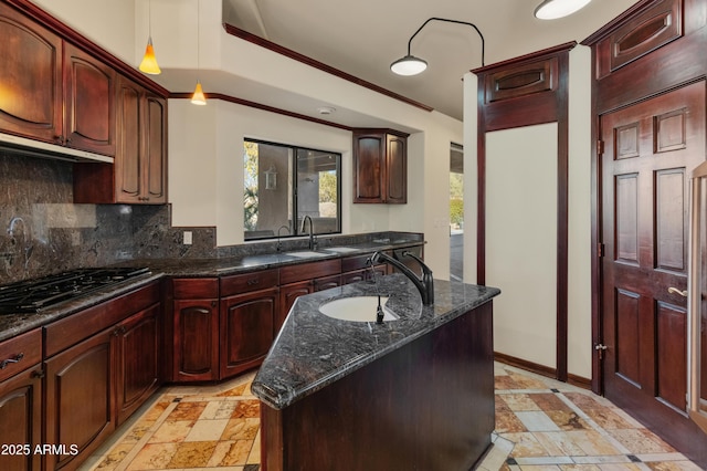 kitchen with a kitchen island, sink, dark stone countertops, and stainless steel gas cooktop