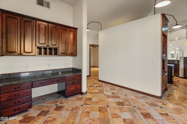 kitchen with dark stone countertops and built in desk