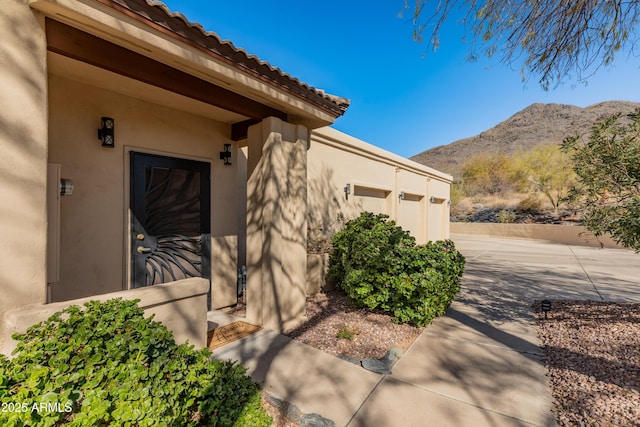 entrance to property featuring a garage and a mountain view