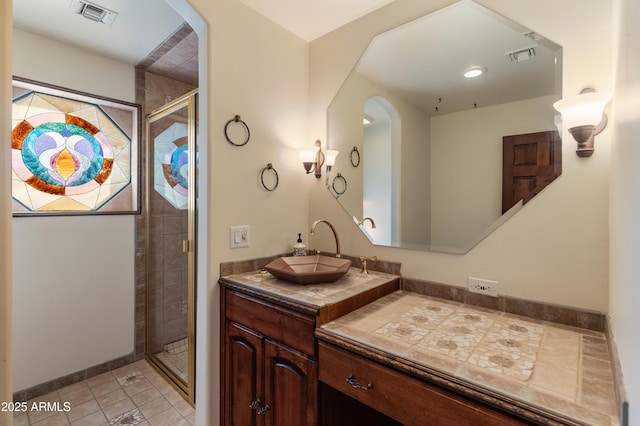 bathroom featuring vanity, tile patterned floors, and a shower with shower door