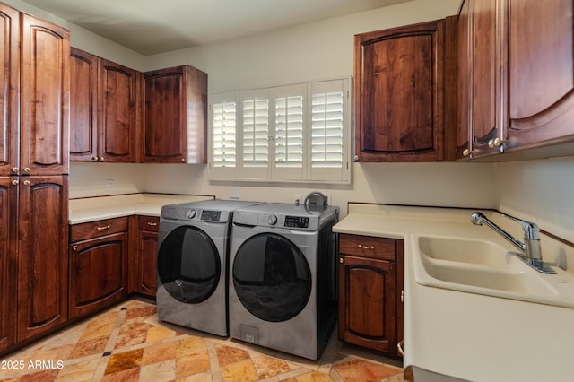 laundry room featuring washer and dryer, sink, and cabinets