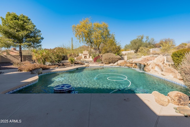 view of swimming pool with pool water feature, exterior fireplace, and a patio area