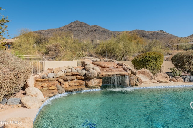 view of swimming pool with a mountain view and pool water feature