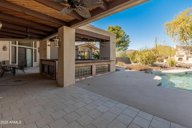 view of patio featuring an outdoor bar and ceiling fan