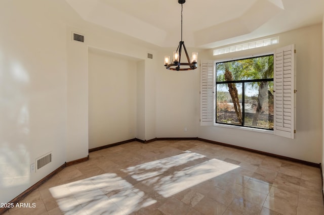 unfurnished dining area featuring an inviting chandelier and a raised ceiling