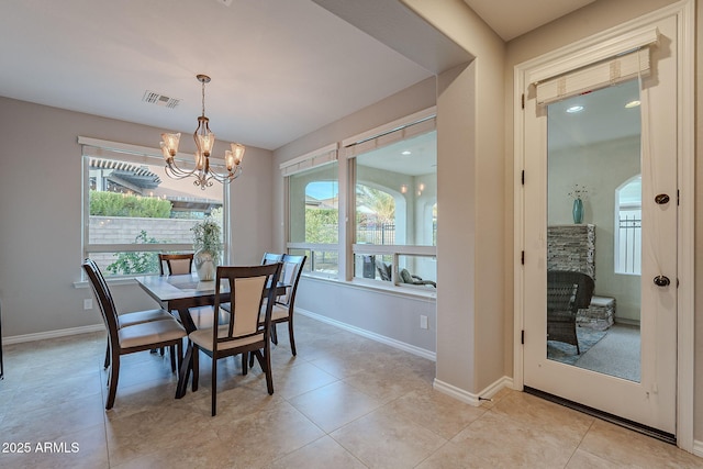 dining space with baseboards, visible vents, a chandelier, and light tile patterned flooring