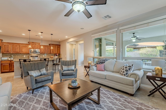 living area with light tile patterned flooring, plenty of natural light, and visible vents