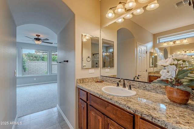 bathroom with ceiling fan, vanity, baseboards, visible vents, and tile patterned floors